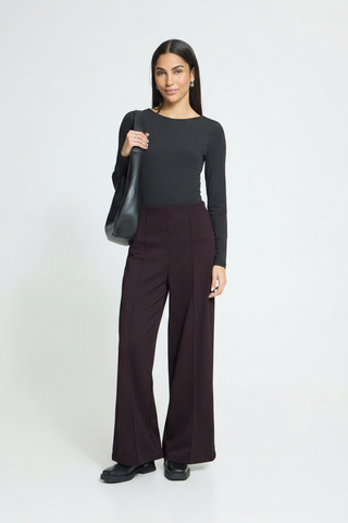 Model with burgundy trousers